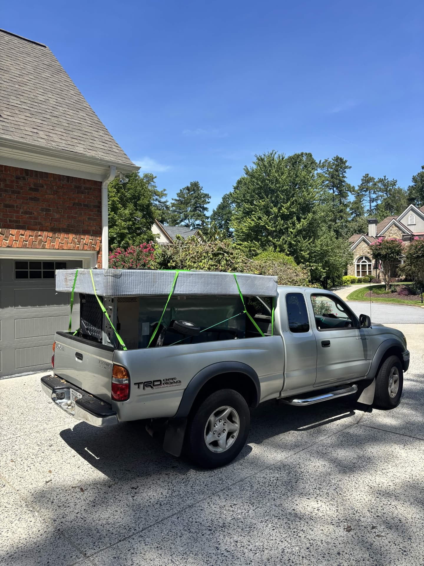 Bad Boys Junk Removal truck loaded with household junk and secured with straps in an Alpharetta driveway