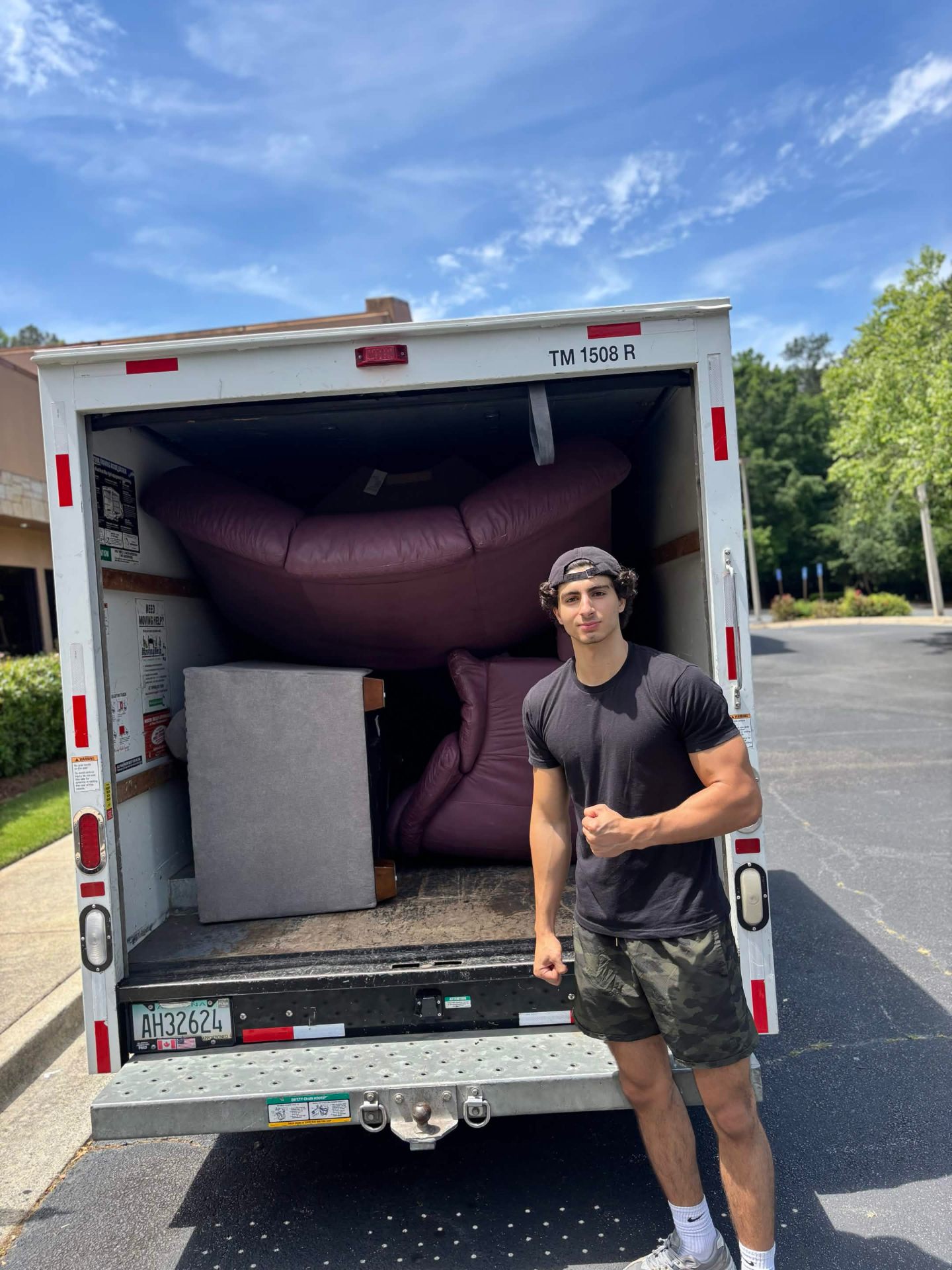 Ali and Trey, founders of Bad Boys Junk Removal, standing by their loaded junk removal truck in North Atlanta
