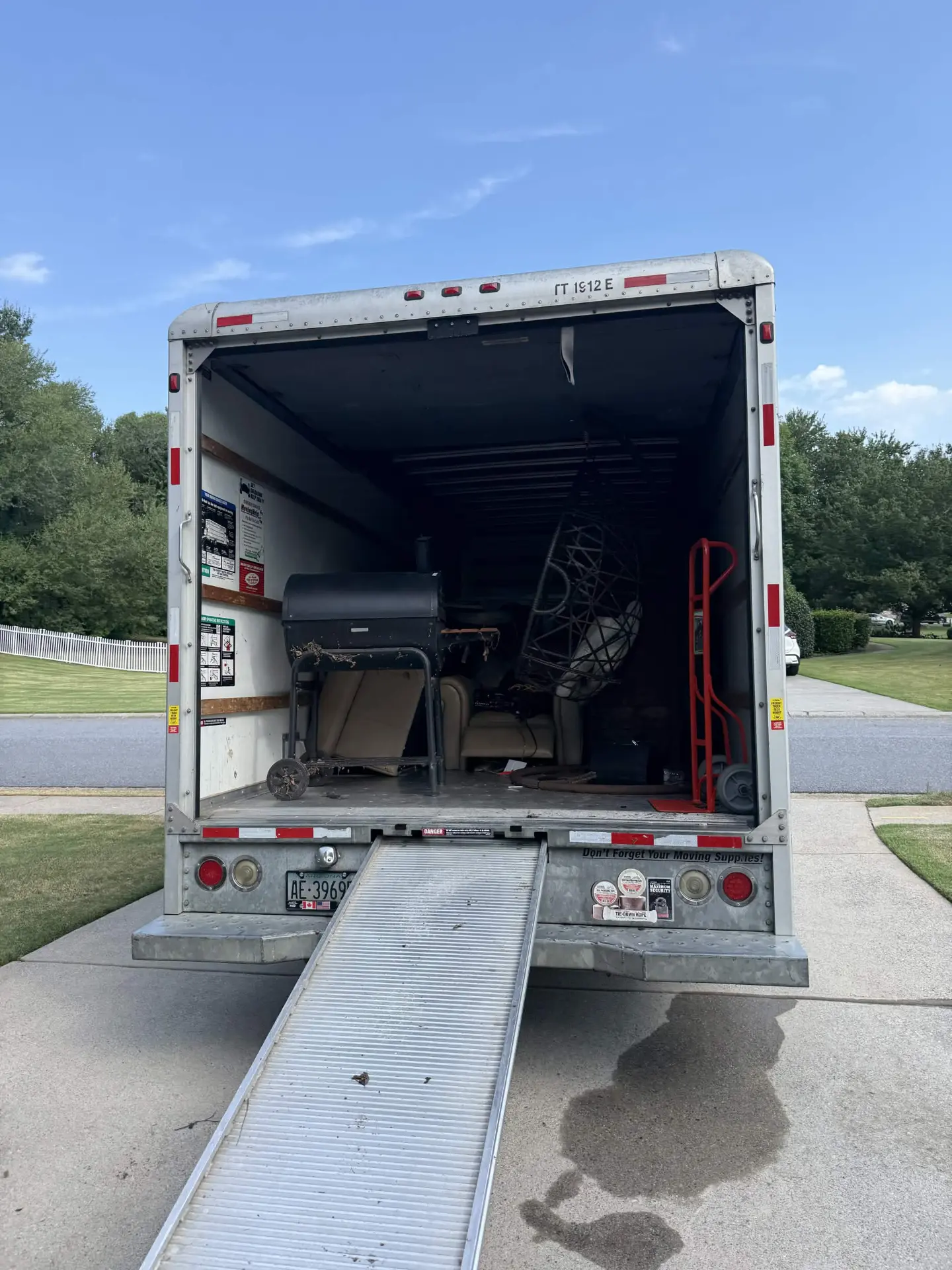 Bad Boys Junk Removal truck with the ramp down, loaded with couches and furniture in North Atlanta
